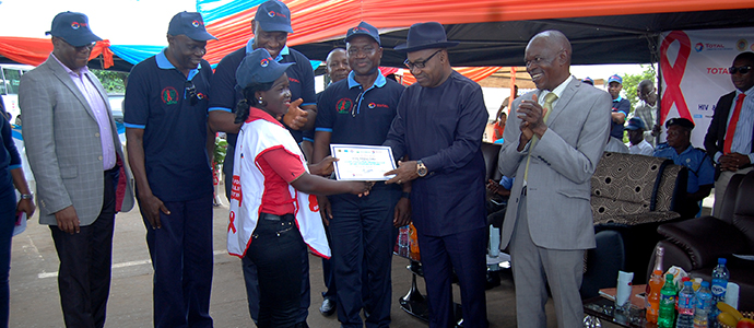 Hon. Festus Ovie Agas the SSG Delta State Presenting a Certificate to one of the Trained Peer Educators