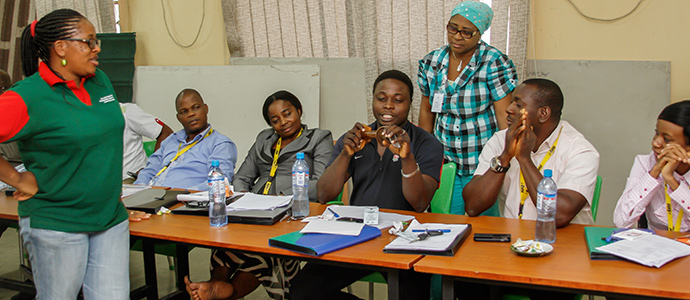 Participants demonstarting the use of a condom at a training